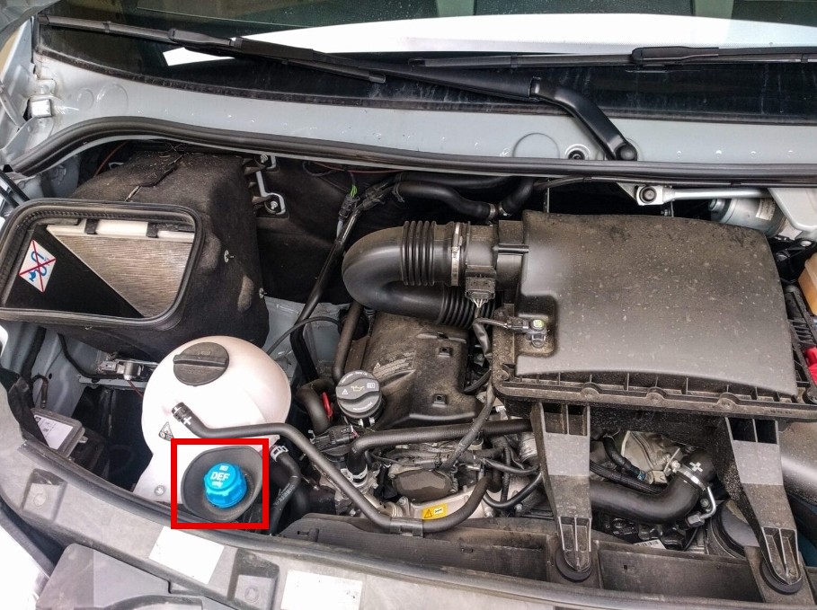 Sprinter engine bay with the blue DEF fill cap outlined in red